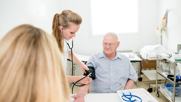 Verpleegkundige meet bloeddruk bij patiënt